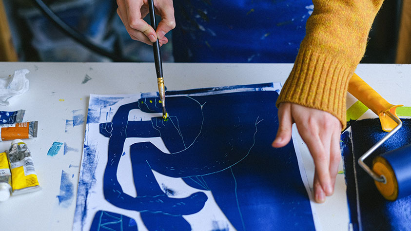 artist painting onto a screenprint